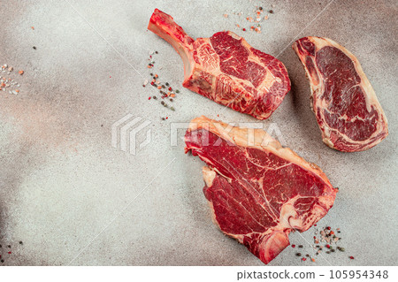 Variety of Raw Black Angus Prime meat steaks T-bone, tomahawk, New York steak. Set raw marbled beef strip loin steaks. place for text, top view Variety of Raw Black Angus Prime meat steaks T-bone, tomahawk, New York steak. Set raw marbled beef strip loin steaks. place for text, top view 105954348