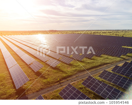 Aerial top view of a solar panels power plant. Photovoltaic solar panels at sunrise and sunset in countryside from above. Modern technology, climate care, earth saving, renewable energy concept. Aerial top view of a solar panels power plant. Photovoltaic solar panels at sunrise and sunset in countryside from above. Modern technology, climate care, earth saving, renewable energy concept. 105954546