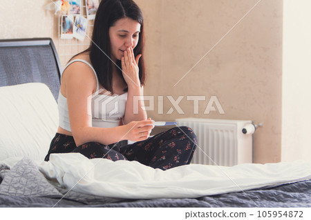 worried woman with positive pregnancy test worried woman with positive pregnancy test 105954872