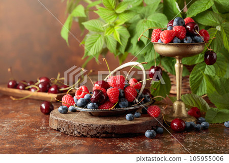Berries with leaves on an old brown table. 105955006