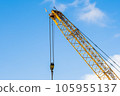 A yellow crane at a construction site during a sunny day 105955137