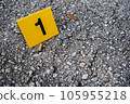 One yellow crime scene evidence marker on the street after a gun shooting brass bullet shell casing 9mm handgun pistol 105955218