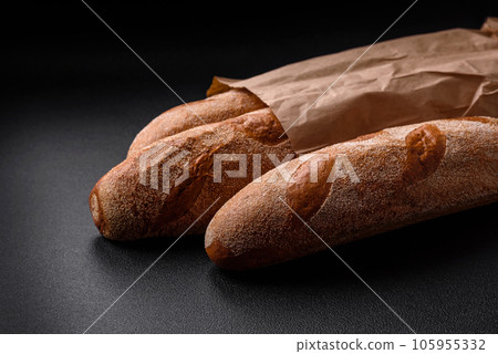 French baguette bread on a dark textured concrete background French baguette bread on a dark textured concrete background 105955332