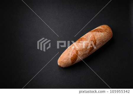 French baguette bread on a dark textured concrete background French baguette bread on a dark textured concrete background 105955342