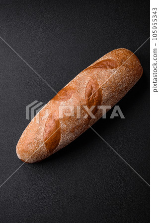 French baguette bread on a dark textured concrete background French baguette bread on a dark textured concrete background 105955343