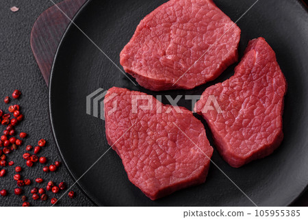 Juicy fresh raw beef meat with salt, spices and herbs Juicy fresh raw beef meat with salt, spices and herbs 105955385