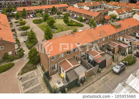 an aerial view of some houses in the city, with cars parked on the street and people walking around them an aerial view of some houses in the city, with cars parked on the street and people walking around them 105955660