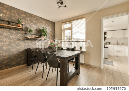 a dining room with wood flooring and wallpapers on the walls, there is a wooden table set for four chairs a dining room with wood flooring and wallpapers on the walls, there is a wooden table set for four chairs 105955670