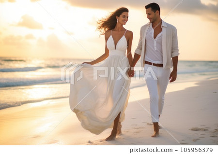 Couple dressed in white walking on the beach Couple dressed in white walking on the beach 105956379