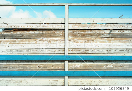 Wooden wood wall texture background, vintage tone or blank template. The wall of the old barn in the bright sun. Weathered and sun-bleached wooden boards with remnants of old blue and white paint Wooden wood wall texture background, vintage tone or blank template. The wall of the old barn in the bright sun. Weathered and sun-bleached wooden boards with remnants of old blue and white paint 105956849