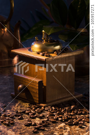 Retro coffee grinder on the table next to coffee beans. Manual coffee mill, vertical shot, selective focus Retro coffee grinder on the table next to coffee beans. Manual coffee mill, vertical shot, selective focus 105957271