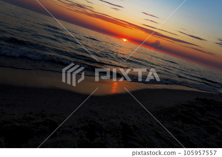 Sunset over the water on a dark background of sunlight over the Mediterranean Sea 105957557