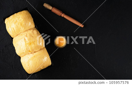 Brioche dough on a tray proofing dough before baking. Baked concept. Top view with copy space 105957576