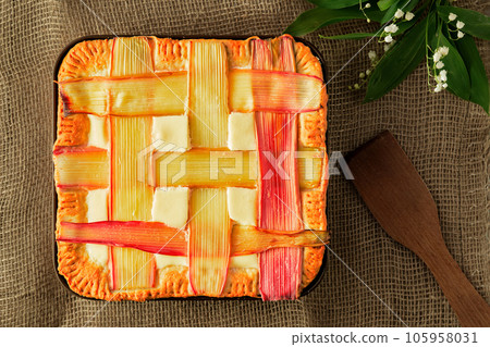 Homemade rhubarb pie on a table with rough linen bedding, horizontal layout top view of a freshly baked tart, flat lay 105958031