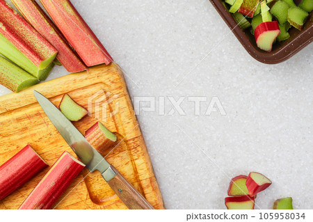 Organic rhubarb on a cutting board, cooking homemade English pie, laying out on a kitchen table, the process of preparing a traditional British tart 105958034