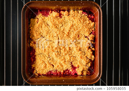 Traditional English crumble tart with rhubarb with baked topping served as close-up in backing form, top view Traditional English crumble tart with rhubarb with baked topping served as close-up in backing form, top view 105958035