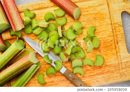 Fresh organic rhubarb on a cutting board, making homemade english crumble tart, top view 105958039
