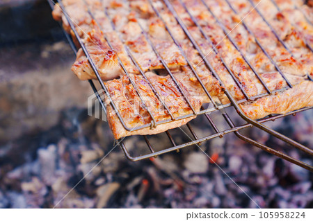 pieces of turkey meat on the grill grate.  105958224