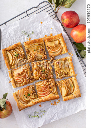 Apple tart with puff pastry tpped with walnuts and brown sugar 105959270