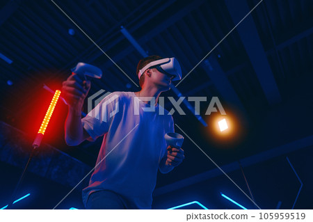 A man plays virtual reality games. VR headset and controllers. A man plays virtual reality games. VR headset and controllers. 105959519