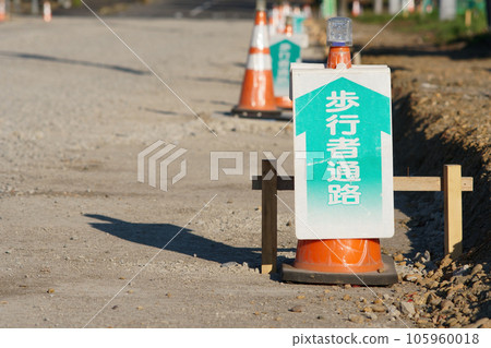 A triangular cone (pedestrian passage) installed on the road at a road construction site A triangular cone (pedestrian passage) installed on the road at a road construction site 105960018