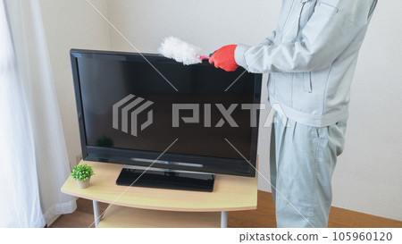 穿著工作服的男人用方便的拖把清除電視上的灰塵 穿著工作服的男人用方便的拖把清除電視上的灰塵 105960120