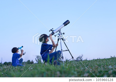 Elementary school boy who observes astronomical objects side by side Elementary school boy who observes astronomical objects side by side 105960128