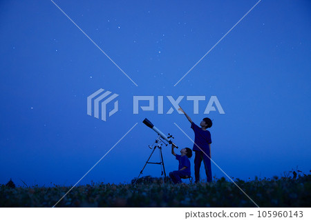 Elementary school boy doing astronomical observation under the night sky 105960143