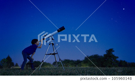 Elementary school boy doing astronomical observation under the sky full of stars 105960148