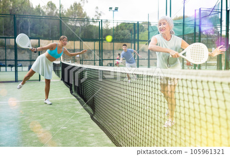 Women playing padel tennis match during training on court 105961321