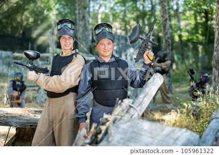 Portrait of positive man and teenage boy paintball players 105961322