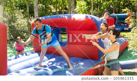 Man with hoop playing tug of war game with opponent outdoors Man with hoop playing tug of war game with opponent outdoors 105961335