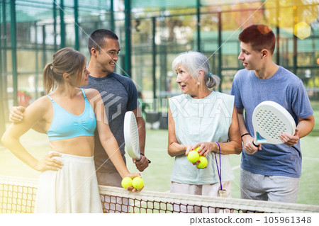 Different aged men and women talking after padel tennis match 105961348