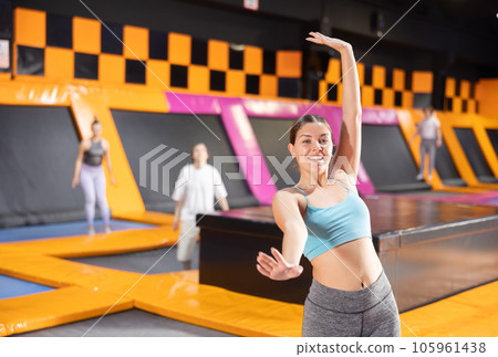 Young woman trains jumping in trampoline center Young woman trains jumping in trampoline center 105961438