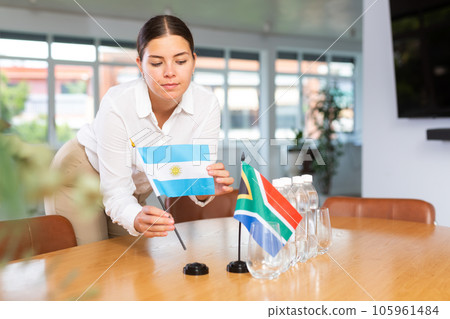 Preparing for business presentation - secretary places flags of Argentina and South Africa on negotiating table 105961484
