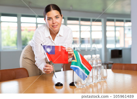 Businesswoman arranging the flags of Taiwan and South Africa for presentation and negotiations 105961489