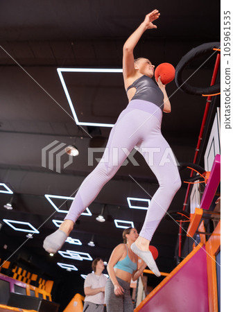 Adult woman playing ball in trampoline center 105961535