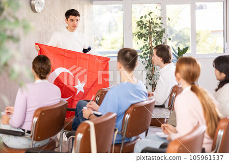 Young male professor showing turkish flag to group of students Young male professor showing turkish flag to group of students 105961537