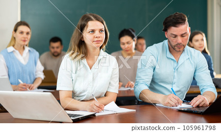 Focused students write down the lecture synopsis during the class 105961798