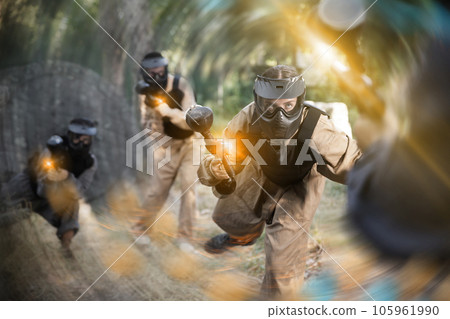 Young woman paintball player rushing through enemy lines 105961990
