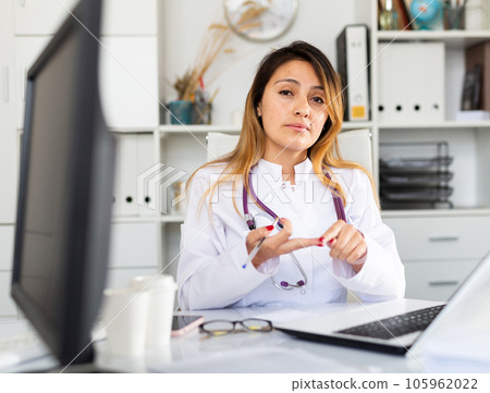 Female doctor working on laptop in office 105962022