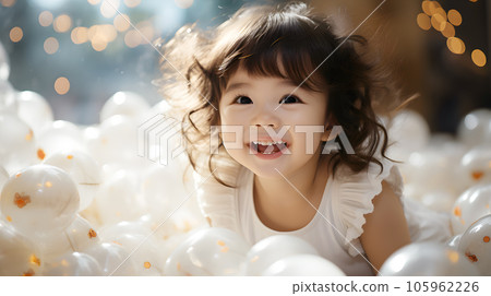 A little smiling Asian baby girl playing bubbles and toy doll in white room at home. Daughter of Family 105962226