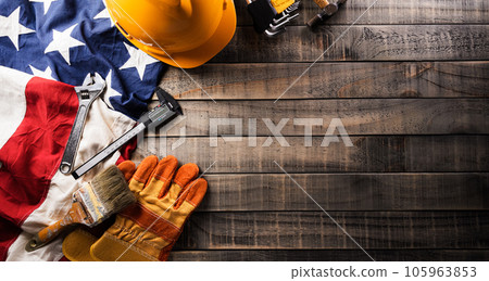 Happy Labor day concept. American flag with different construction tools on dark wooden background. Happy Labor day concept. American flag with different construction tools on dark wooden background. 105963853