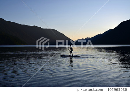 Silhouetted male paddleboarder on Lake Crescent in Olympic National Park. 105963986
