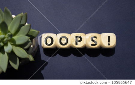 Oops symbol. Concept word Oops on wooden cubes. Beautiful deep blue background with succulent plant. Business and Oops concept. Copy space. Oops symbol. Concept word Oops on wooden cubes. Beautiful deep blue background with succulent plant. Business and Oops concept. Copy space. 105965647