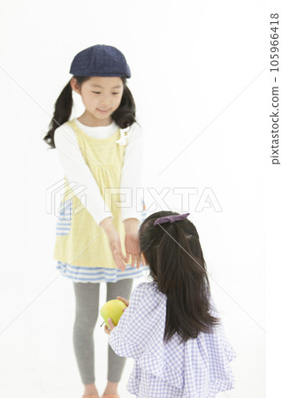 一個戴著帽子的女孩和一個拿著蘋果的嬰兒 105966418