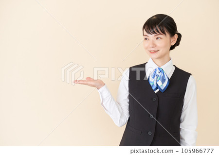 一位從事接待工作和文書工作的女性,穿著絲帶領帶制服,背心上有手工引導 一位從事接待工作和文書工作的女性,穿著絲帶領帶制服,背心上有手工引導 105966777