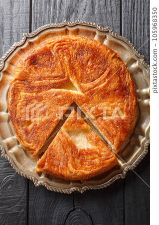 Kouign-amann is a sweet Breton cake made with laminated dough closeup on the plate. Vertical top view Kouign-amann is a sweet Breton cake made with laminated dough closeup on the plate. Vertical top view 105968350