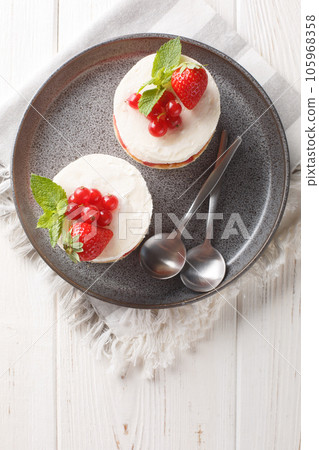French mini Cake Fraisier With Fresh Strawberries and redcurrant closeup on the plate. Vertical top view 105968358