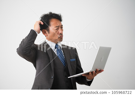 Business image of a middle-aged man operating a laptop while worrying Business image of a middle-aged man operating a laptop while worrying 105968722